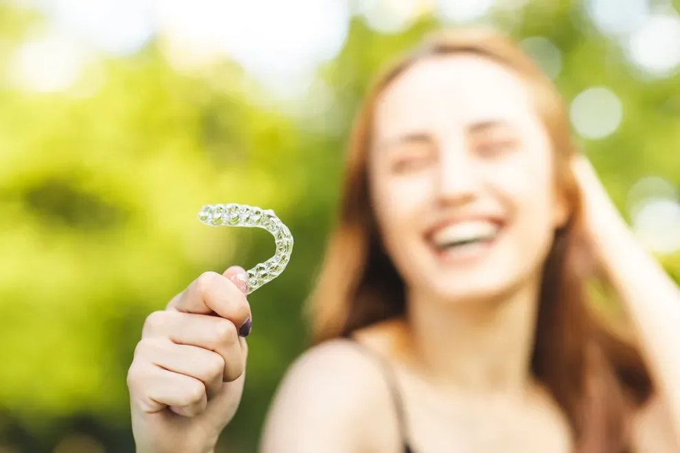 girl-holding-aligner-outside