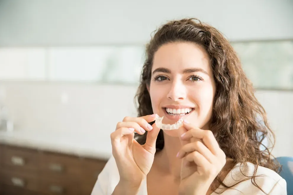 woman-holding-teeth-aligners