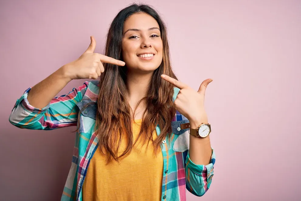 woman-smiling-pointing-at-throat